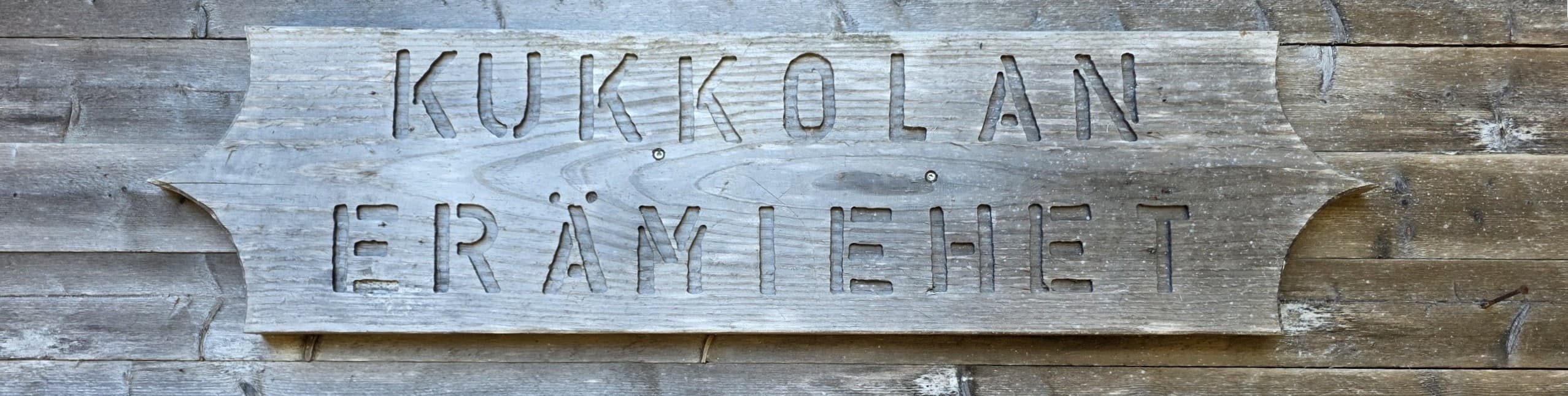 Puinen kyltti: Kukkolan Erämiehet